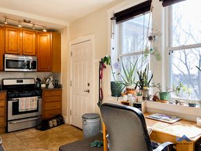 Chicago apartment for rent - a kitchen with a table and a chair in front of a window