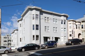 San Francisco apartment for rent - A street view of a building with cars parked in front.
