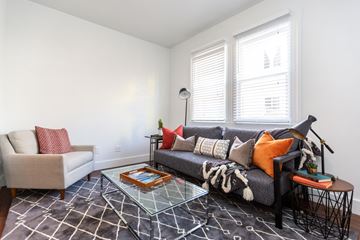 San Francisco apartment for rent - a living room with a couch and a chair and two windows