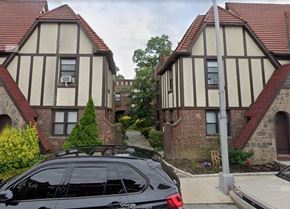 Flushing apartment for rent - a car parked in front of two houses