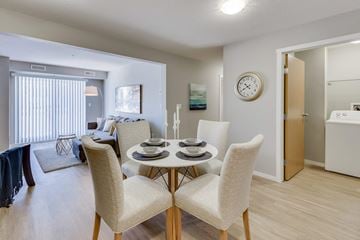 Kelowna apartment for rent - A dining room with a table set for two and a clock on the wall.