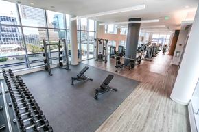 Baltimore apartment for rent - a gym with weights and cardio equipment in a building with large windows