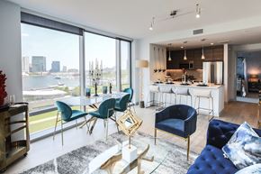 Baltimore apartment for rent - a living room and kitchen with a view of a river and a city