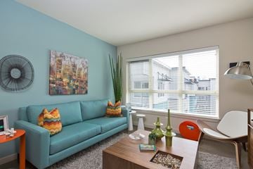 Seattle apartment for rent - A living room with a blue couch and a painting on the wall.