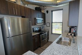 Plymouth apartment for rent - A kitchen with a stainless steel refrigerator and a granite countertop.