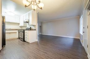 Pasadena apartment for rent - A kitchen with white cabinets and a black refrigerator.