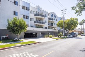 Burbank apartment for rent - A street view of a white apartment building with a black garage door.
