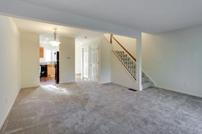 Amherst townhouse for rent - an empty living room with a staircase and a kitchen