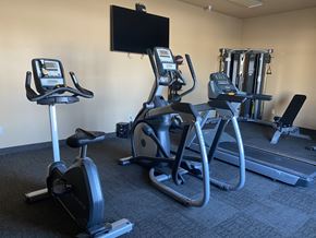 Stanley apartment for rent - a gym with cardio equipment and a tv