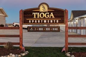 Tioga apartment for rent - a sign for toga apartments in front of a driveway