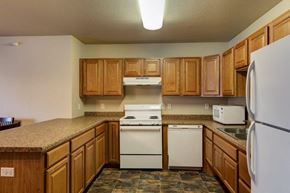 Tioga apartment for rent - a kitchen with white appliances and wooden cabinets