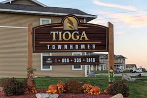 Tioga townhouse for rent - a sign for toga townhomes in front of a building