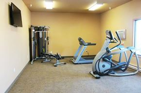 Tioga apartment for rent - a gym with weights and a tv on the wall