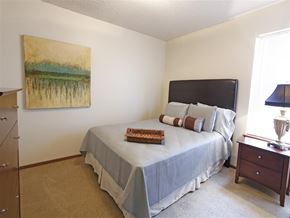 Fayetteville apartment for rent - a bedroom with a large bed and a painting on the wall