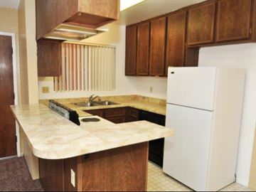 Lakeside apartment for rent - a kitchen with a white refrigerator and a sink