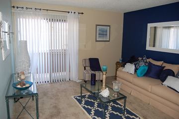 Las Vegas apartment for rent - A living room with a glass coffee table and a striped chair.