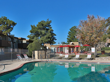 El Paso apartment for rent - A swimming pool surrounded by trees and chairs.