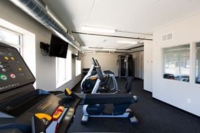 Sturgeon Bay apartment for rent - a gym with a treadmill and a tv on the wall