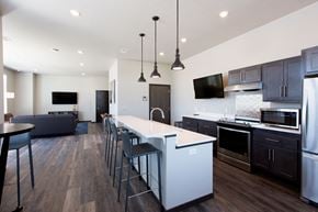 Sturgeon Bay apartment for rent - a large kitchen with a large island with a white counter top and dark cabinets