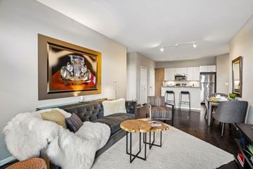Auburn Hills apartment for rent - A living room with a grey couch and a painting on the wall.