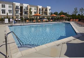 Auburn Hills apartment for rent - a swimming pool with an apartment building in the background