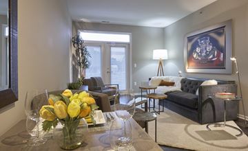 Auburn Hills apartment for rent - a living room with a couch and a table with yellow flowers