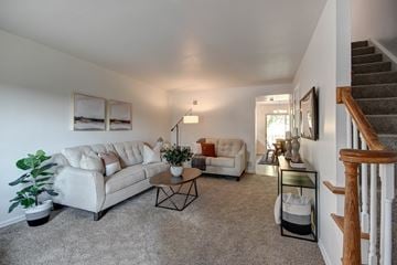 St. Louis townhouse for rent - the living room of a house with white couches and a staircase