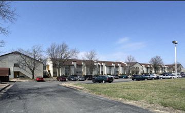 Tulsa apartment for rent - a row of apartment buildings with cars parked in a parking lot