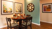 Peoria apartment for rent - a dining room with a table and chairs and paintings on the wall