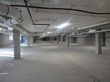Hopkins apartment for rent - A spacious underground parking garage with concrete pillars and bright lighting.