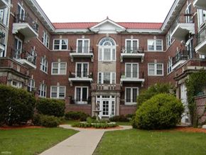 Rockford apartment for rent - a red brick apartment building with a sidewalk and grass