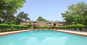 Winston-Salem apartment for rent - A swimming pool surrounded by trees and chairs.
