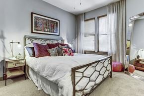 Houston apartment for rent - the master bedroom has a large bed with white sheets and pillows