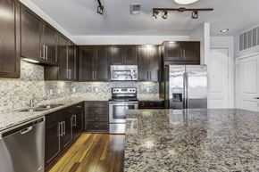 Houston apartment for rent - a kitchen with granite counter tops and dark wood cabinets