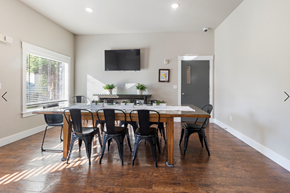 Tumwater apartment for rent - a dining room with a large table and chairs and a tv on the wall
