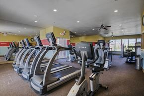 Bryant apartment for rent - a gym with cardio equipment and a ceiling fan