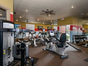 North Little Rock apartment for rent - a gym with cardio machines and a ceiling fan