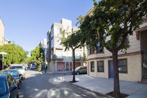 San Francisco apartment for rent - A tree is in front of a building with a blue car parked on the street.