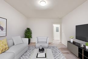 San Francisco apartment for rent - A living room with a grey couch, a white armchair, a coffee table, and a flat-screen TV.