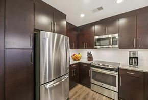 Washington apartment for rent - A kitchen with dark wood cabinets and stainless steel appliances.