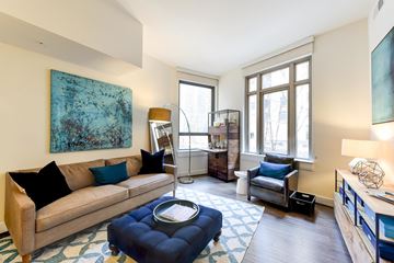 Washington apartment for rent - A living room with a blue ottoman and a couch.