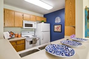 Fountain Valley apartment for rent - full kitchen with white appliances and blue and white plates on the counter