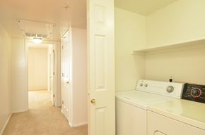Scottsdale apartment for rent - a laundry room with a washer and dryer and a hallway with a door