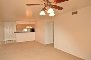 Scottsdale apartment for rent - an empty living room with a ceiling fan and a kitchen