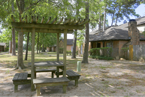 Conroe apartment for rent - a picnic area with benches and a pergola