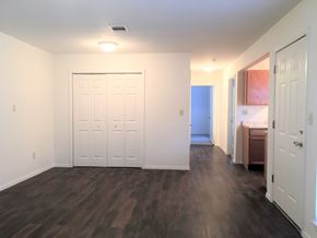 Conroe apartment for rent - an empty living room with a white door and a bathroom