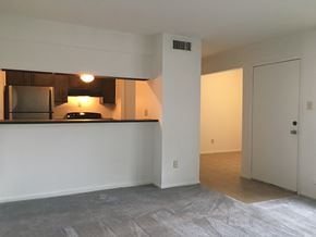 Houston apartment for rent - an empty living room with a kitchen and a door to a bedroom
