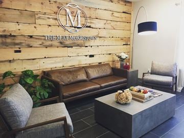 Morristown apartment for rent - a living room with couches and chairs and a table with a basket of fruit