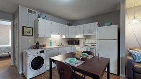 Greenville apartment for rent - a kitchen with a washer and dryer and a dining room with a table