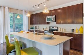 Sandy Springs apartment for rent - A kitchen with a white island and green chairs.
